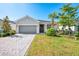 Charming single-story home featuring a gray two-car garage, paver driveway, and well-manicured landscaping at 10995 Pinot Dr, Venice, FL 34293