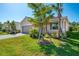 Single-story home featuring a gray two-car garage, brick paver driveway, and lush landscaping at 10995 Pinot Dr, Venice, FL 34293