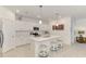 Bright kitchen with white cabinets, stainless appliances, pendant lights, island, and breakfast bar seating at 10995 Pinot Dr, Venice, FL 34293
