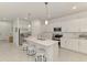 Island kitchen with stainless steel appliances, pendant lighting, and bar stool seating at 10995 Pinot Dr, Venice, FL 34293