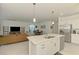 Open concept living featuring kitchen island with sink, stainless dishwasher, and view into living and dining areas at 10995 Pinot Dr, Venice, FL 34293