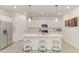 Bright kitchen with white cabinetry, quartz countertops, stainless appliances, pendant lighting, and island with seating at 10995 Pinot Dr, Venice, FL 34293