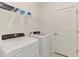 Practical laundry room featuring a washer, a dryer, storage shelving, and a door, for efficient home chores at 10995 Pinot Dr, Venice, FL 34293