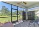 Covered patio with screen, brick floor, fan, and a beautiful view of the manicured yard at 10995 Pinot Dr, Venice, FL 34293