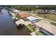 Aerial view of the home, boat dock and lift, the outdoor screened in pool and adjacent homes at 12596 Bacchus Rd, Port Charlotte, FL 33981