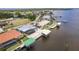 Stunning aerial view of a waterfront home with a private dock, boat lift and beautiful tropical landscaping at 12596 Bacchus Rd, Port Charlotte, FL 33981