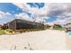 Backyard with white gravel, landscaping, and screened-in pool at 12596 Bacchus Rd, Port Charlotte, FL 33981