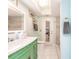 Bathroom featuring a bright vanity with a green cabinet base and a door leading to the outside at 12596 Bacchus Rd, Port Charlotte, FL 33981