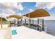 View of the covered boat lift on the white dock with seating with serene waters in the background at 12596 Bacchus Rd, Port Charlotte, FL 33981