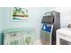 Bright laundry room area featuring an ice machine, turquoise colored cabinet, and beach themed decor at 12596 Bacchus Rd, Port Charlotte, FL 33981