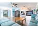 Open-concept living room with hardwood floors, a ceiling fan, and views into the kitchen and lanai at 12596 Bacchus Rd, Port Charlotte, FL 33981