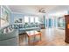 Bright living room with blue walls, wood floors, comfortable seating, and natural light at 12596 Bacchus Rd, Port Charlotte, FL 33981
