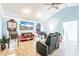 Spacious living room with light blue walls, ceiling fan, and unique pinball machine decor at 12596 Bacchus Rd, Port Charlotte, FL 33981