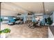 Expansive covered patio area with tile flooring, ceiling fans, and multiple seating arrangements at 12596 Bacchus Rd, Port Charlotte, FL 33981