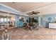 Lovely covered patio with seating arrangements, tiled floor, sliding doors to indoor rooms, and ceiling fan at 12596 Bacchus Rd, Port Charlotte, FL 33981