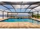 Beautiful pool area with paver deck, screen enclosure, and scenic waterfront views at 12596 Bacchus Rd, Port Charlotte, FL 33981