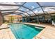 A screened pool with an outside dining area and water view at 12596 Bacchus Rd, Port Charlotte, FL 33981