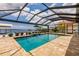 Screened pool with brick surround and a tranquil view of the waterfront at 12596 Bacchus Rd, Port Charlotte, FL 33981