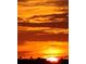 Bright orange sunset view through the clouds at this property at 12596 Bacchus Rd, Port Charlotte, FL 33981