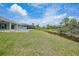 Spacious backyard with waterway views from grey house, ideal for relaxation and enjoying nature at 13972 Chesswood Ln, Port Charlotte, FL 33981