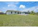 Expansive backyard with a grey home, covered patio, and screened-in pool, perfect for outdoor living at 13972 Chesswood Ln, Port Charlotte, FL 33981