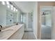 Bathroom with dual sinks, white cabinets, and glass shower at 13972 Chesswood Ln, Port Charlotte, FL 33981