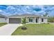 Attractive single-Gathering home with grey siding, manicured lawn, and a spacious two-car garage at 13972 Chesswood Ln, Port Charlotte, FL 33981