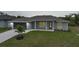 Twilight view of a cozy home with grey siding, a well-lit entrance, and landscaped front yard at 13972 Chesswood Ln, Port Charlotte, FL 33981