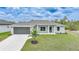Charming single-story home with a well-manicured lawn, gray exterior, and a two-car garage at 13972 Chesswood Ln, Port Charlotte, FL 33981