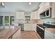Functional kitchen showcasing stainless appliances, a center island, and a seamless connection to the outdoors at 13972 Chesswood Ln, Port Charlotte, FL 33981