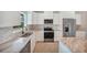 Close-up of a modern kitchen with stainless steel appliances, granite countertops, and white cabinetry at 13972 Chesswood Ln, Port Charlotte, FL 33981