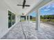 A covered patio with a ceiling fan and stylish gray pavers at 13972 Chesswood Ln, Port Charlotte, FL 33981