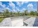 Unfilled pool lined with brick pavers with view of trees and sky at 13972 Chesswood Ln, Port Charlotte, FL 33981