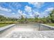 Unfilled pool lined with brick pavers with view of trees, sky, and the rear of the house at 13972 Chesswood Ln, Port Charlotte, FL 33981