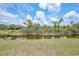 Picturesque waterway view highlighting the lush landscaping surrounding the grey home at 13972 Chesswood Ln, Port Charlotte, FL 33981