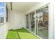 Screened balcony with artificial turf, sliding glass doors, and white door at 150 Harborside Ave # 306, Punta Gorda, FL 33950