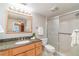 Bright bathroom featuring a shower with glass door, granite countertop, and wood vanity at 150 Harborside Ave # 306, Punta Gorda, FL 33950