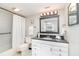 Bathroom featuring a shower-tub combination, black granite countertop, white vanity and framed mirror at 150 Harborside Ave # 306, Punta Gorda, FL 33950