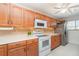 Well-lit kitchen showcasing wooden cabinets, white appliances, and neutral countertops at 150 Harborside Ave # 306, Punta Gorda, FL 33950