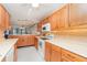 Bright kitchen featuring wooden cabinetry, white countertops, and views into the living area at 150 Harborside Ave # 306, Punta Gorda, FL 33950
