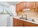 Compact laundry area equipped with a stackable washer and dryer, sink, and wood cabinetry at 150 Harborside Ave # 306, Punta Gorda, FL 33950