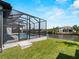 Backyard view of a screened-in pool, covered patio, and a waterfront view at 15504 Melport Cir, Port Charlotte, FL 33981