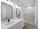A modern bathroom with double sinks, quartz countertops, and a tiled shower at 15504 Melport Cir, Port Charlotte, FL 33981