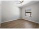 A bright bedroom with wood floors, a ceiling fan, and a window at 15504 Melport Cir, Port Charlotte, FL 33981