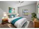 Bright bedroom with a ceiling fan, light hardwood floors, and a turquoise comforter at 15504 Melport Cir, Port Charlotte, FL 33981
