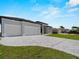 Long driveway leading to a modern home with a spacious two-car garage at 15504 Melport Cir, Port Charlotte, FL 33981