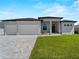 Modern home exterior featuring a 2 car garage, landscaped yard, and stylish entryway at 15504 Melport Cir, Port Charlotte, FL 33981