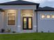 Stylish home exterior with a double-door entryway framed by pillars and a well-kept lawn at 15504 Melport Cir, Port Charlotte, FL 33981