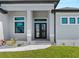 Stunning front entry featuring a double door, decorative windows, and manicured landscaping at 15504 Melport Cir, Port Charlotte, FL 33981