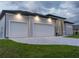 Spacious three-car garage with ample driveway space and contemporary exterior lighting at 15504 Melport Cir, Port Charlotte, FL 33981